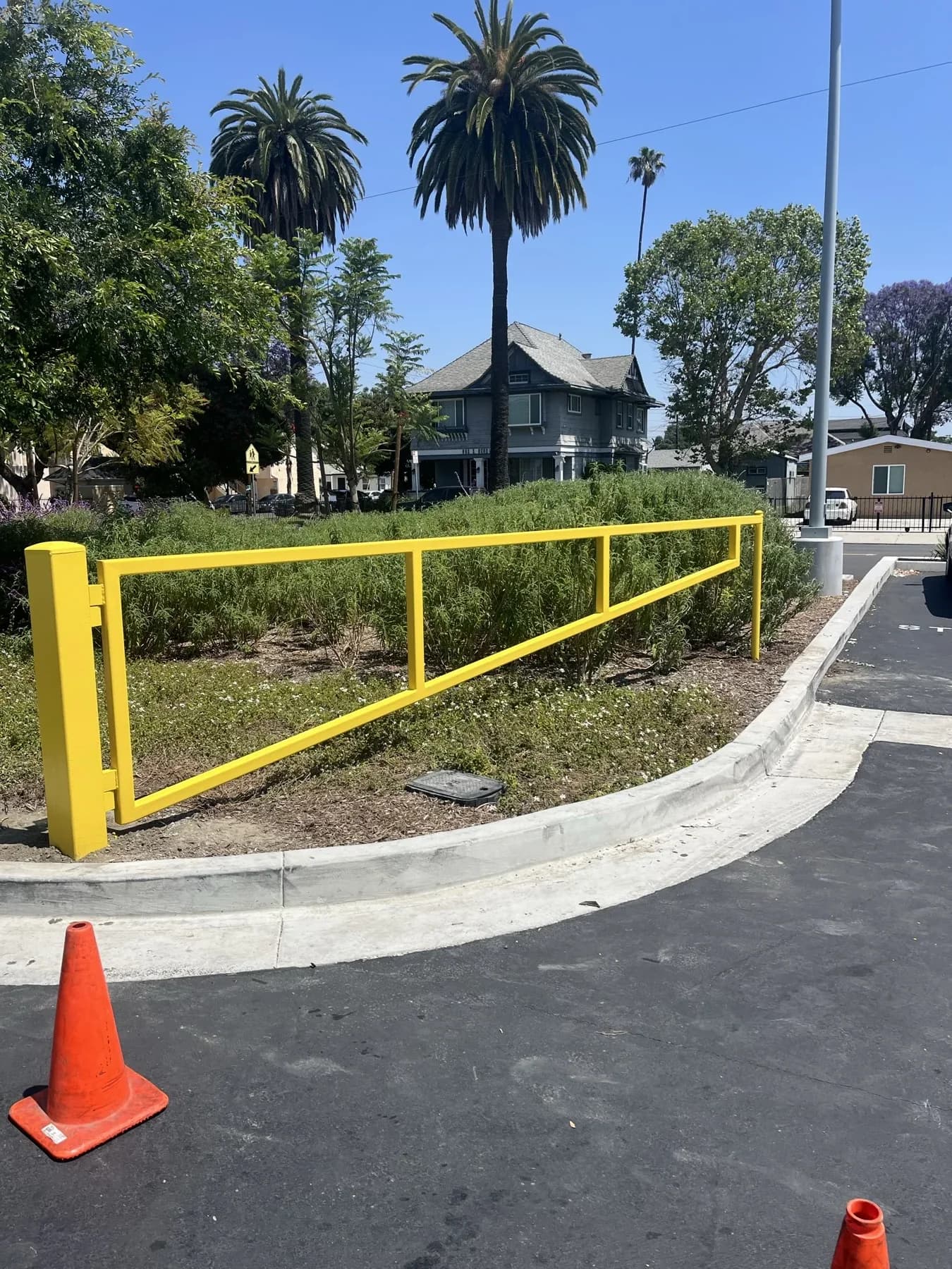 Yellow swing barrier controlling a paved facility access route