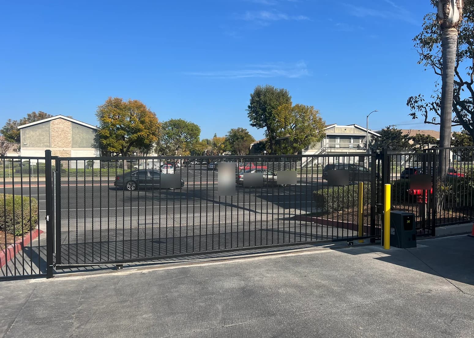 Automated sliding vehicle gate securing a commercial parking entrance