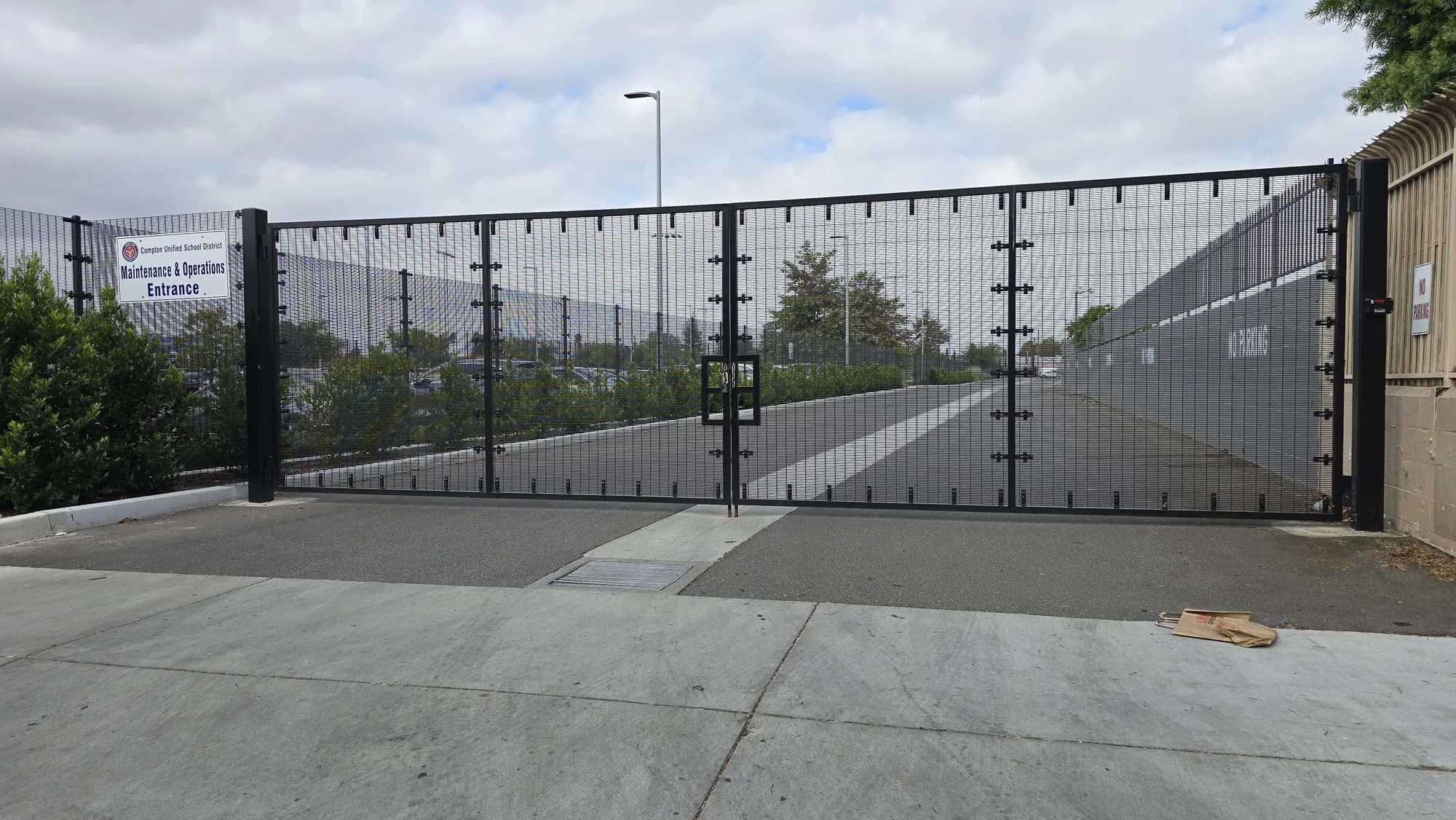 Wide double-swing vehicle gate controlling a maintenance and operations entrance