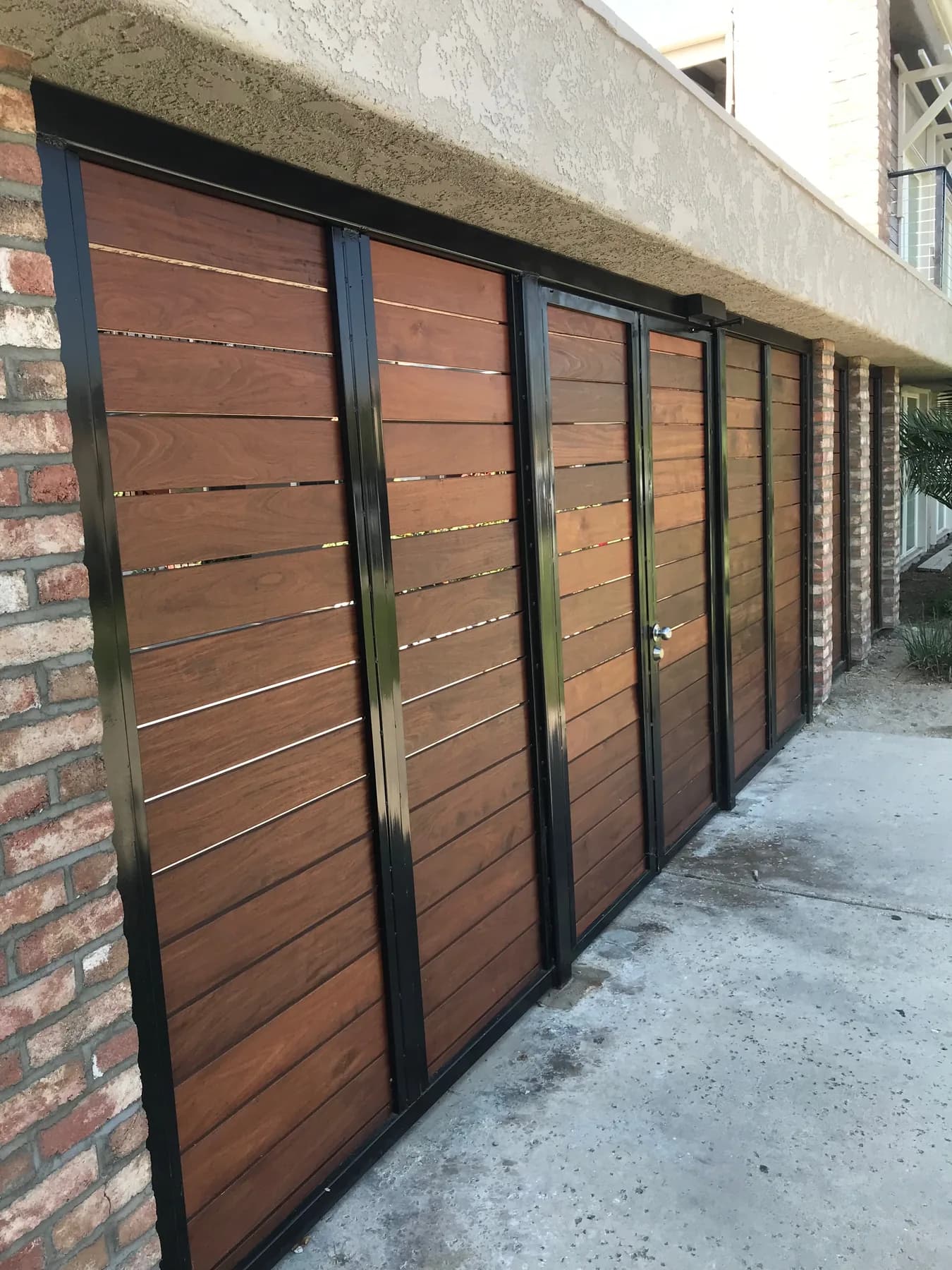 Horizontal wood-infill panels in black metal frames along a building