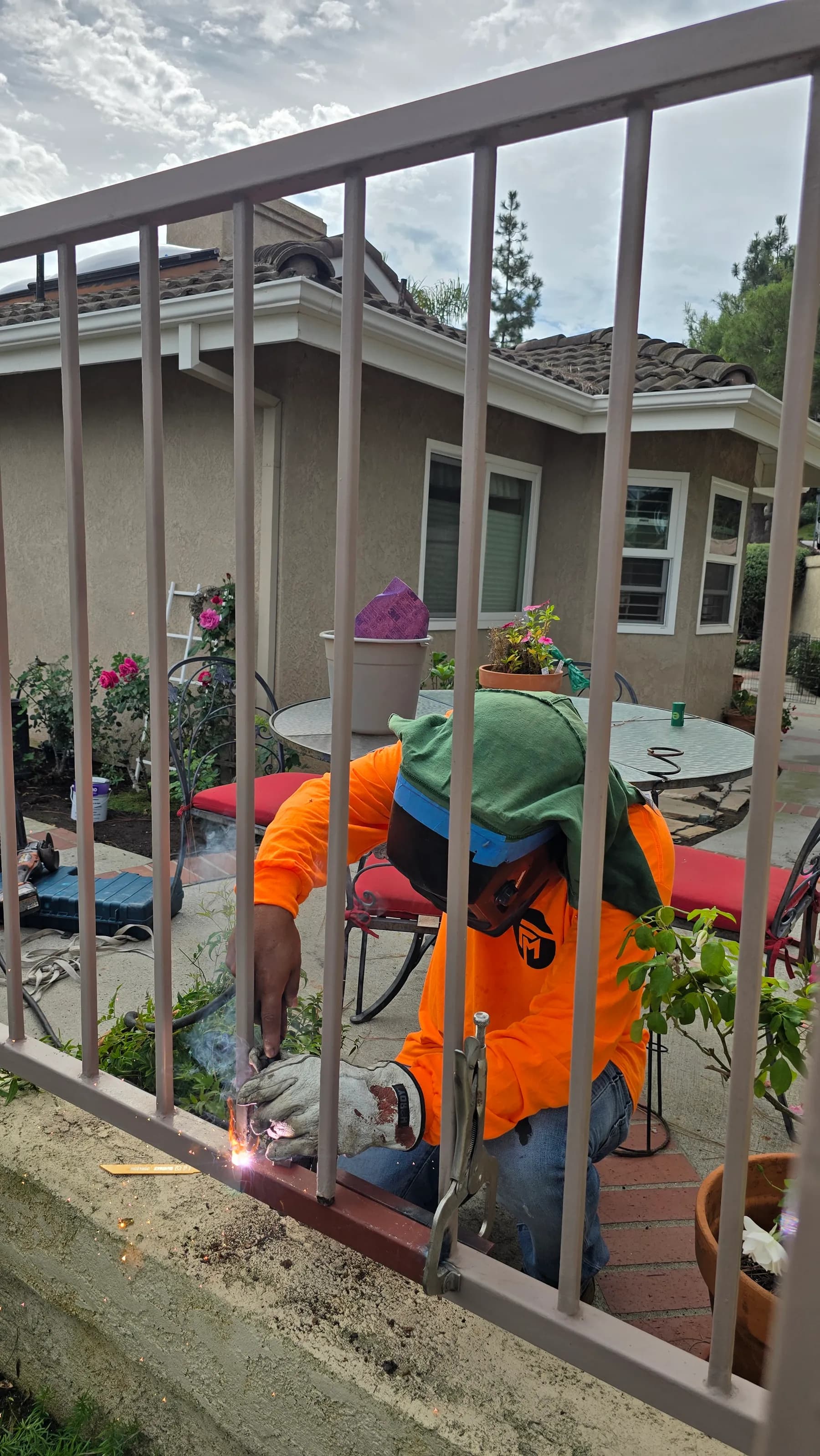 Worker welding a lower connection on a metal guardrail