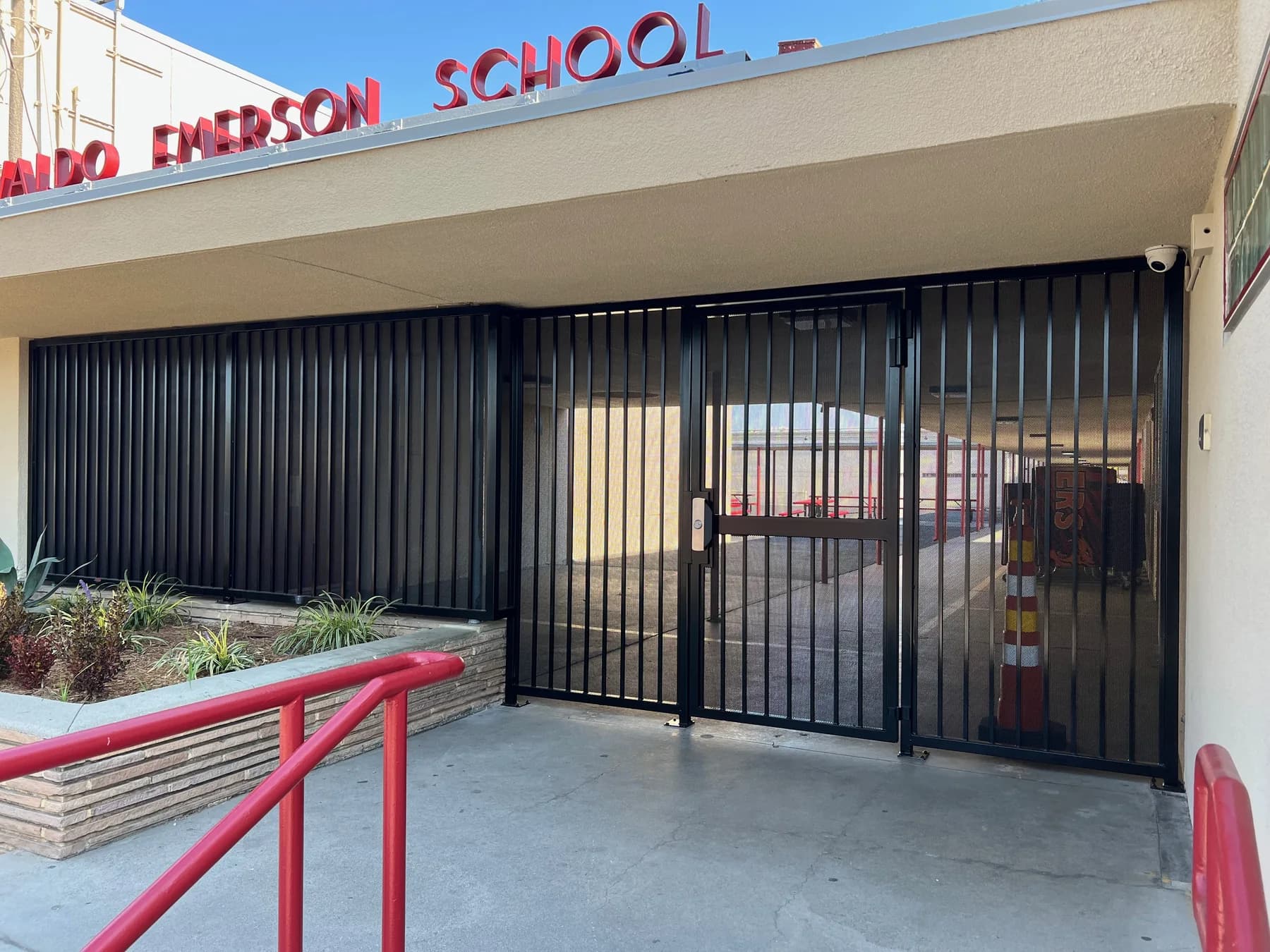 Black pedestrian security gate beneath the Ralph Waldo Emerson School sign