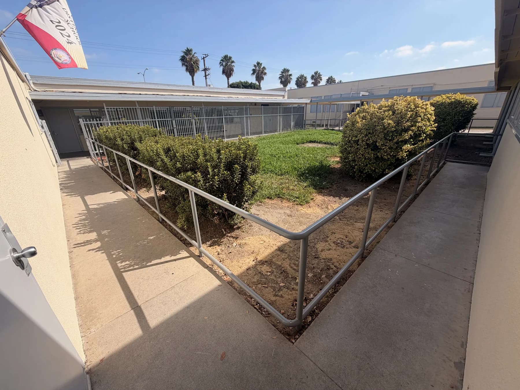 Gray metal guardrails defining covered walkways around a school courtyard