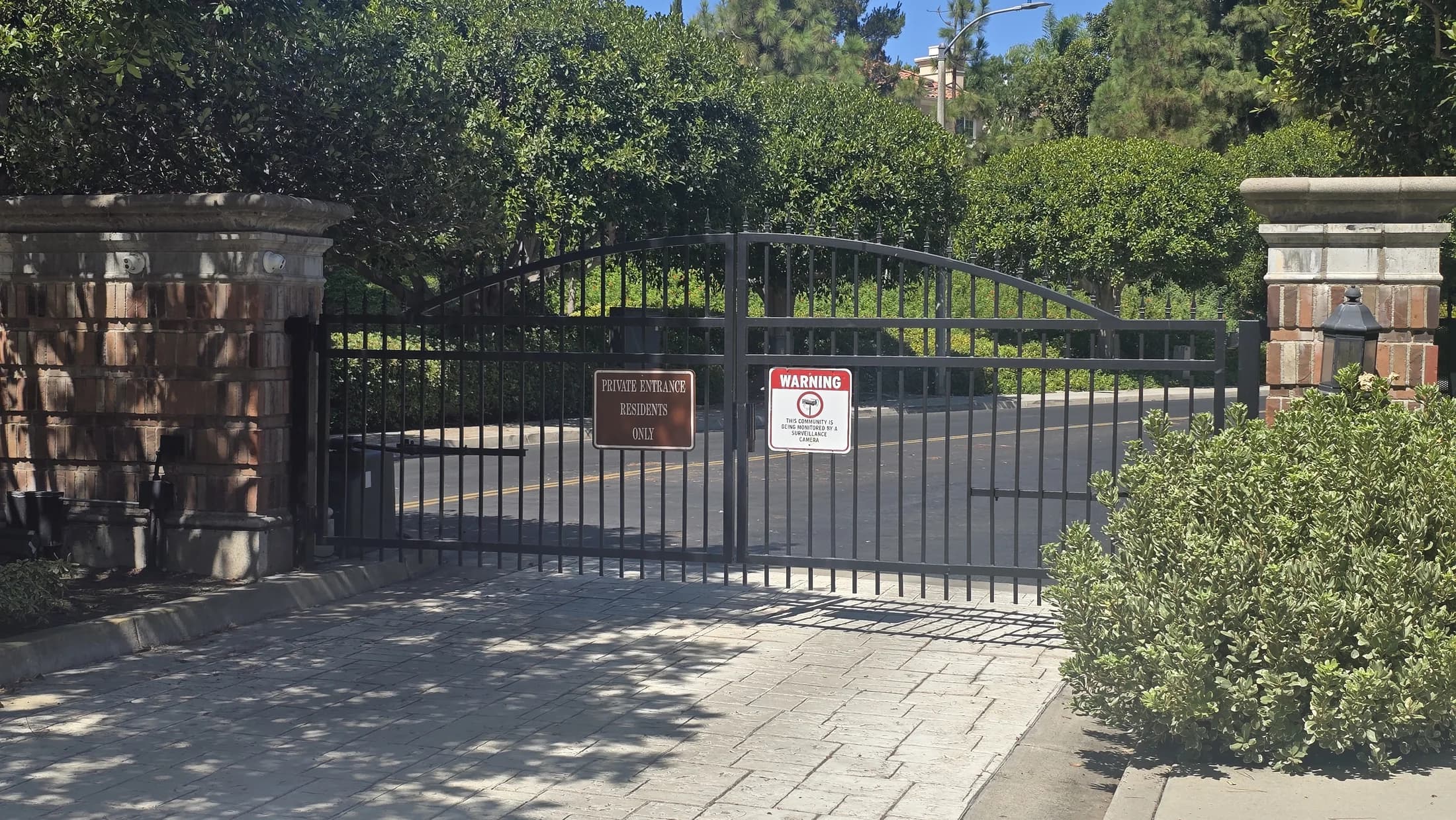Installed black wrought-iron vehicle gate between stone columns at Turtle Rock Summit