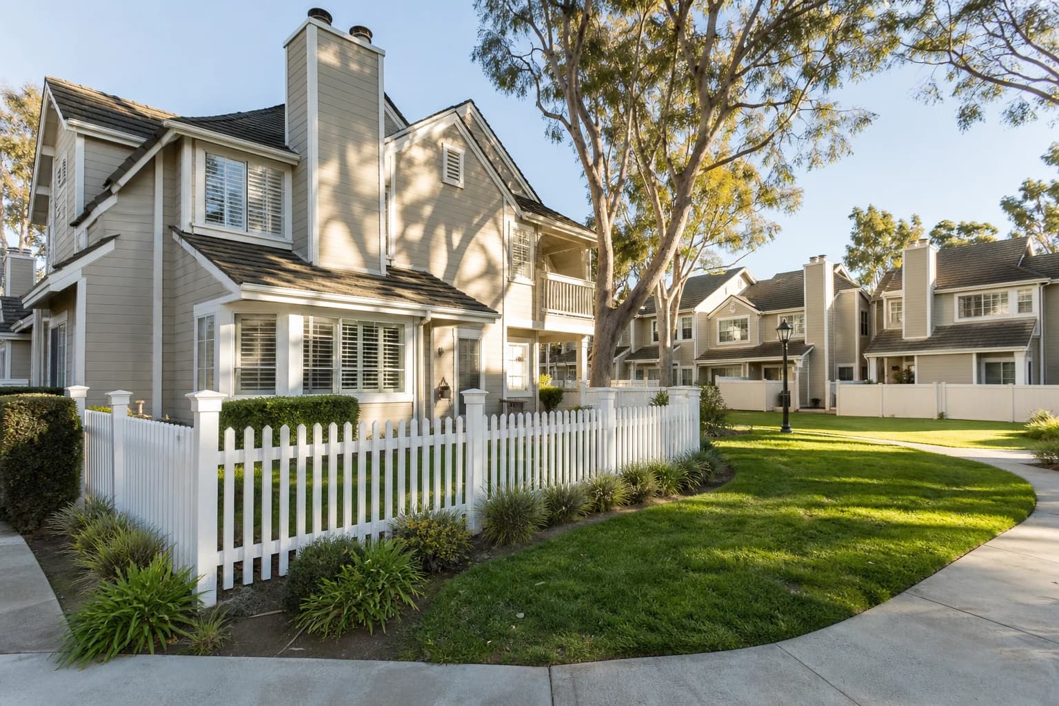 White vinyl fencing along a landscaped residential community